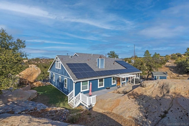 back of house featuring solar panels