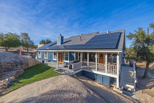 back of house with a lawn and solar panels