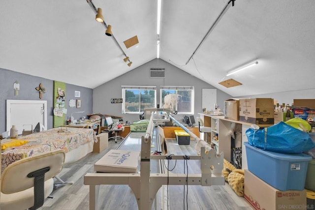 interior space with rail lighting, light hardwood / wood-style floors, and vaulted ceiling