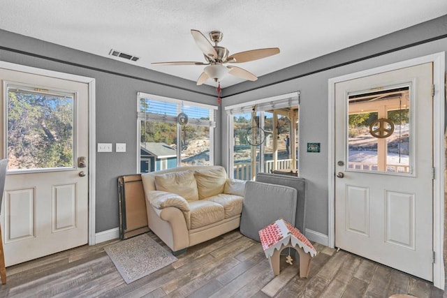 interior space with a wealth of natural light, dark wood-type flooring, and ceiling fan