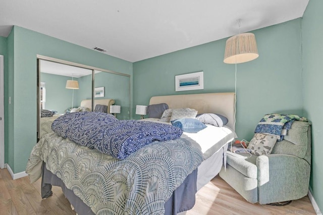 bedroom with light hardwood / wood-style flooring and a closet