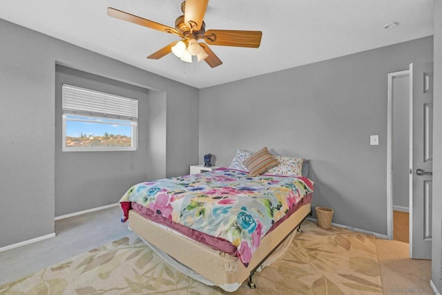 bedroom featuring light carpet and ceiling fan