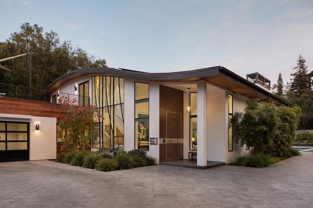 view of front of house featuring a garage and a balcony