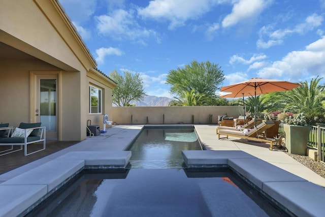 view of pool featuring a mountain view, a patio area, and a jacuzzi