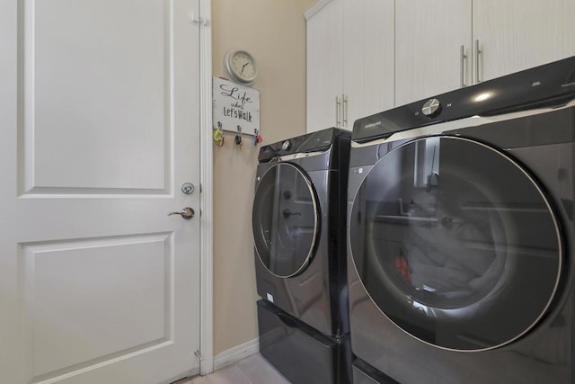 washroom featuring light tile patterned floors, independent washer and dryer, and cabinets