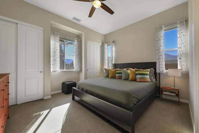 carpeted bedroom featuring ceiling fan and a closet