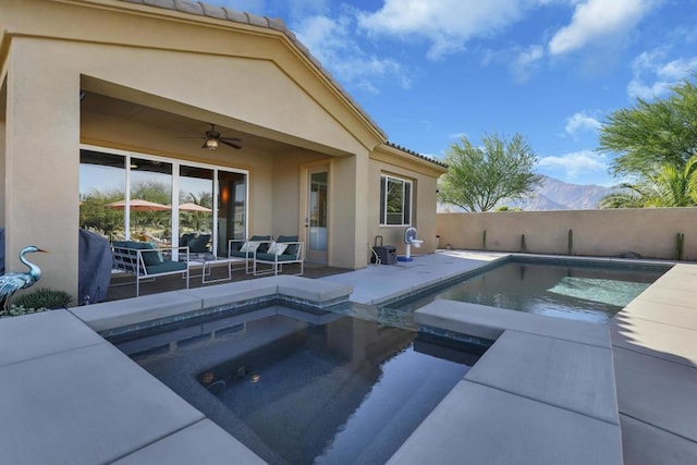 view of pool with a mountain view, ceiling fan, outdoor lounge area, an in ground hot tub, and a patio