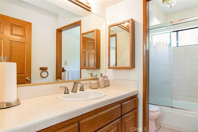 full bathroom featuring tile patterned floors, vanity, toilet, and enclosed tub / shower combo