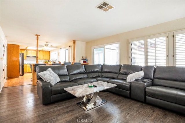 living room featuring dark hardwood / wood-style flooring, ceiling fan, and a healthy amount of sunlight