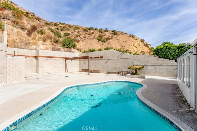 view of swimming pool featuring a mountain view and a patio