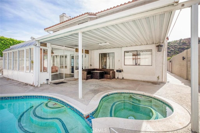 view of swimming pool featuring an in ground hot tub, a patio, and a sunroom