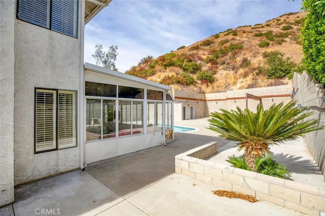 view of patio with a sunroom and a mountain view