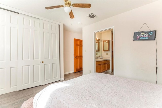 bedroom featuring ensuite bathroom, ceiling fan, sink, light hardwood / wood-style floors, and a closet