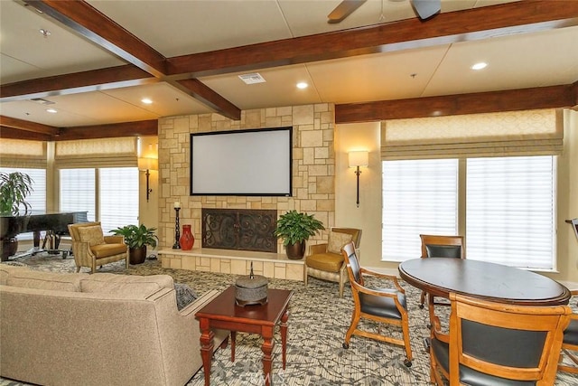 living room featuring ceiling fan, beamed ceiling, and a healthy amount of sunlight