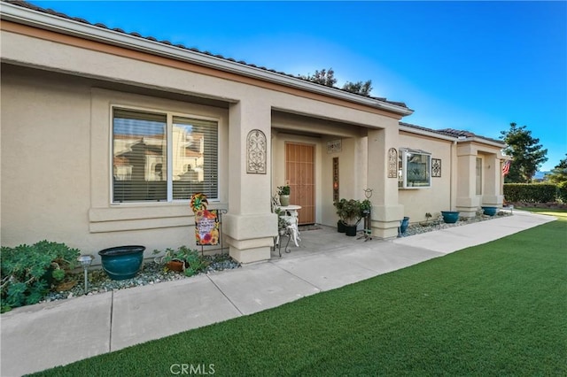 entrance to property featuring a yard