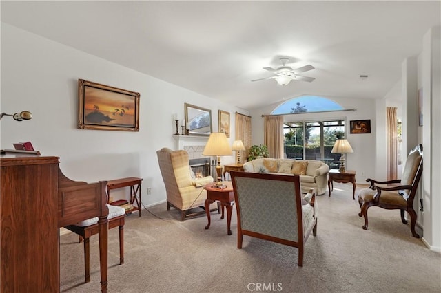 carpeted living room featuring ceiling fan, a tile fireplace, and lofted ceiling