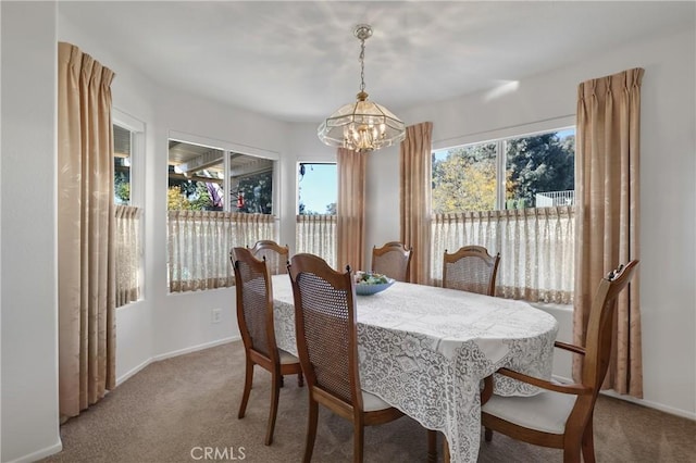 dining area featuring carpet and a chandelier