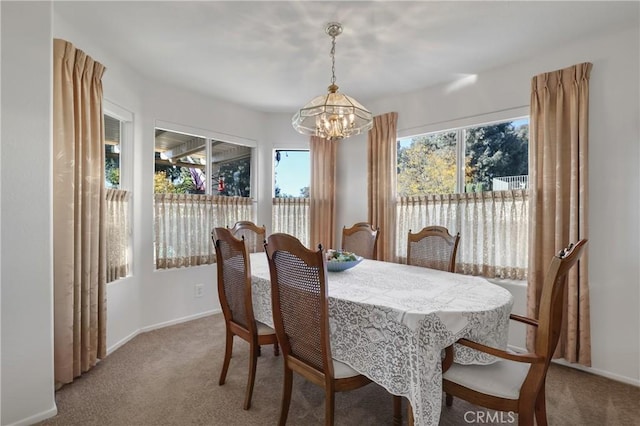 dining room with carpet floors and a chandelier