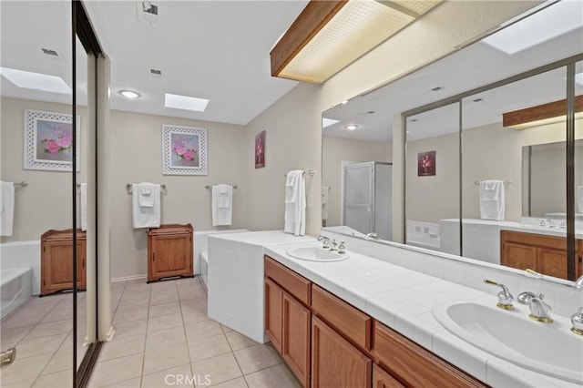 bathroom with plus walk in shower, a skylight, tile patterned floors, and vanity