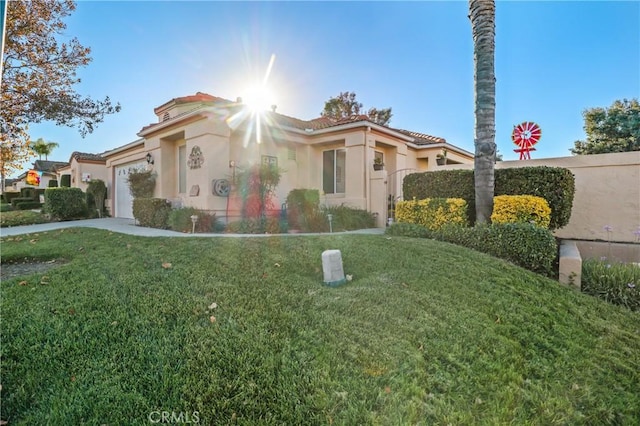 mediterranean / spanish-style home with a front yard and a garage