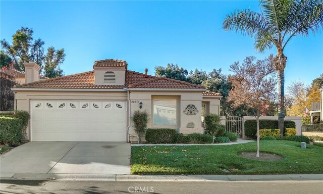 mediterranean / spanish-style house with a front yard and a garage