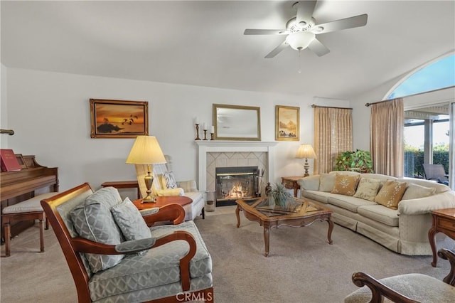 living room with ceiling fan, a tile fireplace, and light carpet