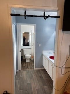 bathroom featuring hardwood / wood-style floors, vanity, and toilet