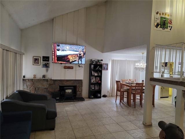 living room with a wood stove, a textured ceiling, an inviting chandelier, and high vaulted ceiling