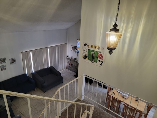 staircase with carpet floors and vaulted ceiling