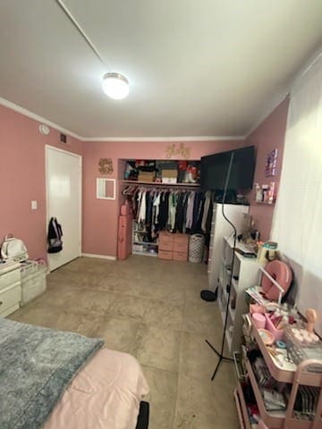 bedroom featuring ornamental molding and a closet