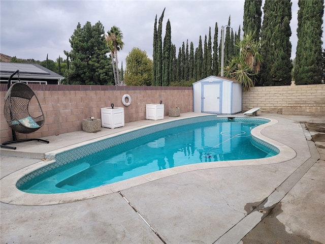 view of pool featuring a shed and a diving board