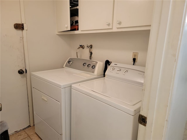 washroom featuring separate washer and dryer, light tile patterned flooring, and cabinets