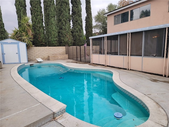 view of pool featuring a sunroom and a shed