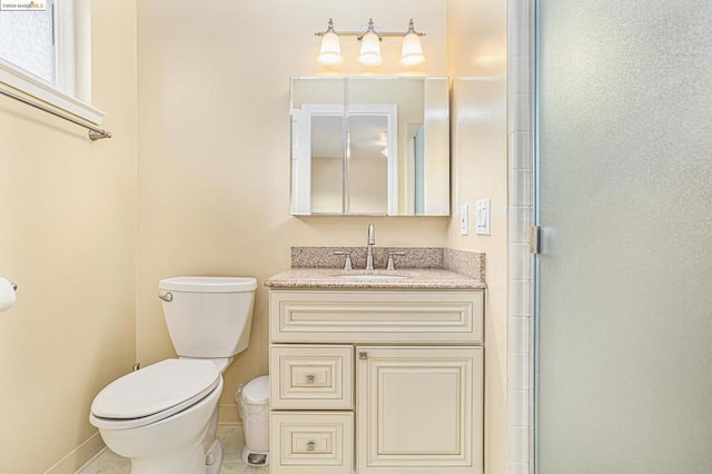 bathroom with an enclosed shower, vanity, and toilet