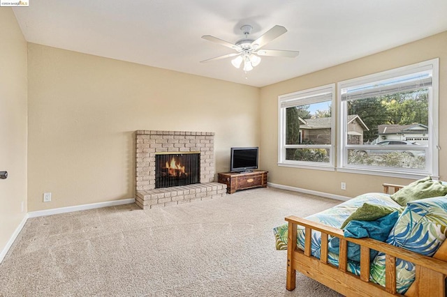 carpeted living room featuring ceiling fan and a fireplace