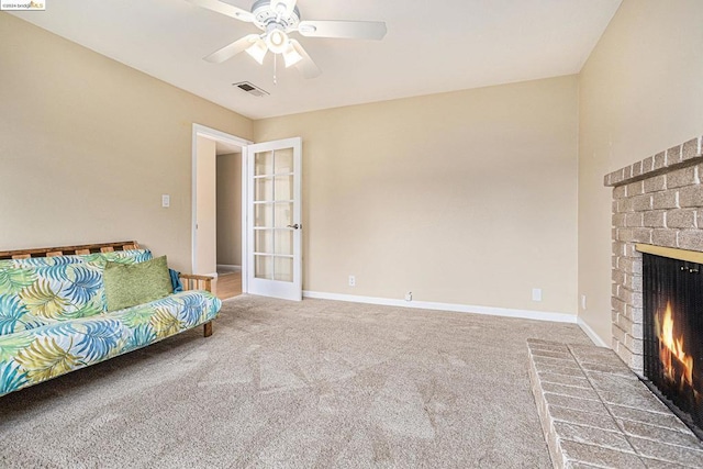 unfurnished living room with ceiling fan, french doors, a fireplace, and carpet flooring