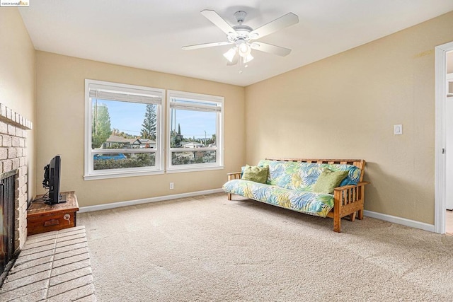 carpeted living room with ceiling fan and a fireplace