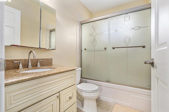 full bathroom featuring enclosed tub / shower combo, vanity, toilet, and tile patterned flooring