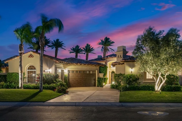 mediterranean / spanish-style home with a yard and a garage