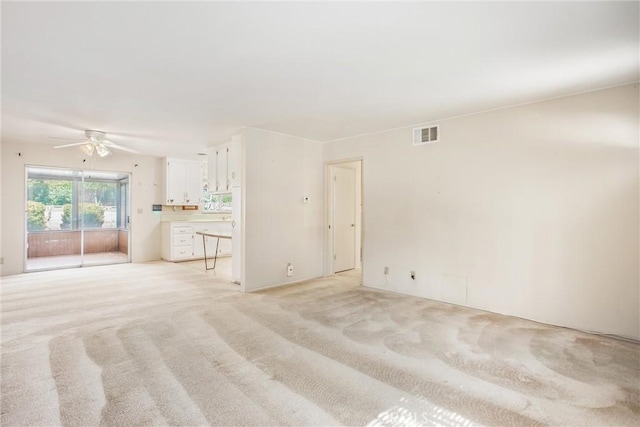 unfurnished living room with light carpet and ceiling fan