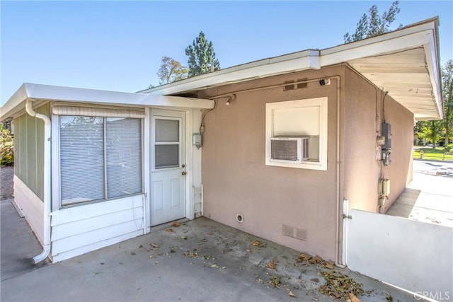 property entrance featuring cooling unit and a patio