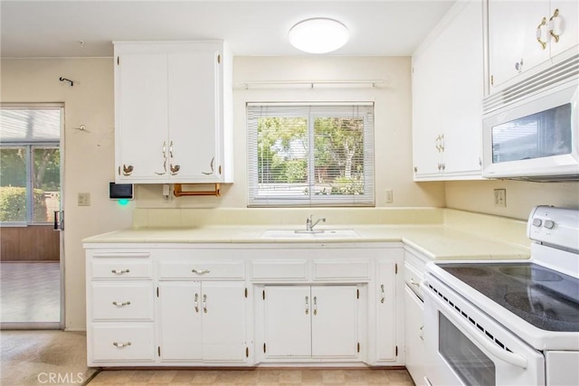 kitchen with white cabinetry, plenty of natural light, sink, and white appliances