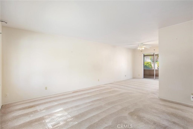 spare room featuring ceiling fan and light carpet