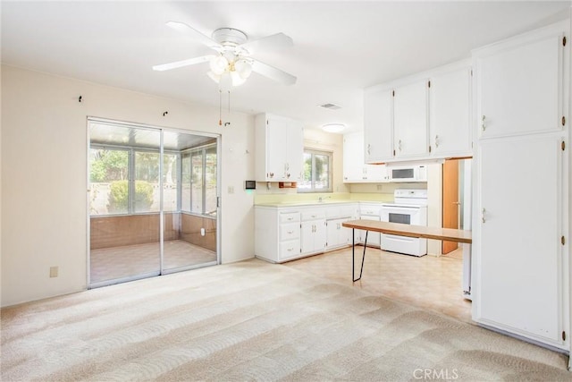 kitchen featuring sink, white cabinetry, light carpet, ceiling fan, and white appliances