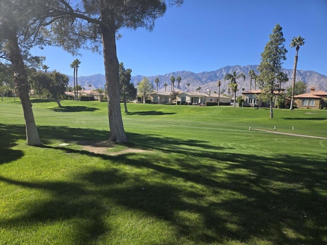 view of property's community with a lawn and a mountain view