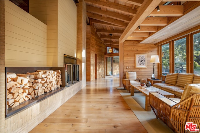 interior space featuring wood walls, beamed ceiling, wood ceiling, and light wood-type flooring