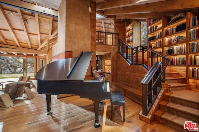 miscellaneous room featuring vaulted ceiling with beams, wooden walls, light hardwood / wood-style flooring, and wooden ceiling