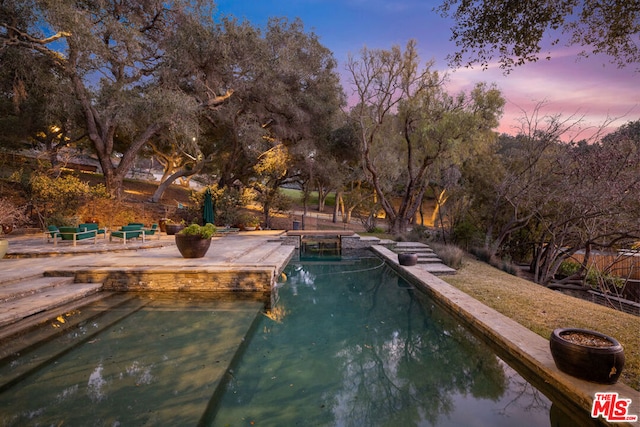 view of pool at dusk