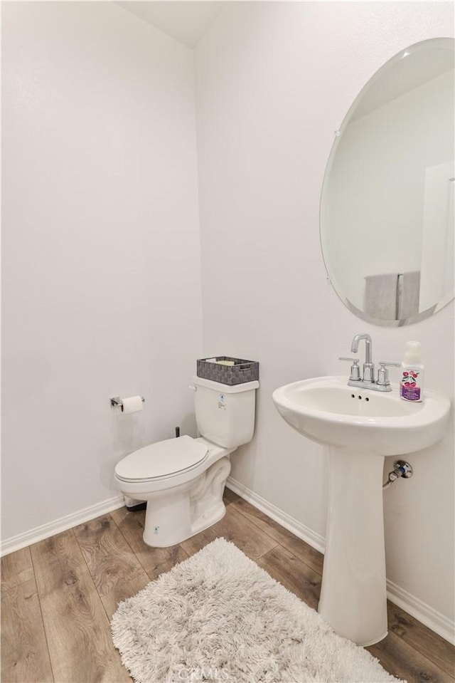 bathroom with sink, wood-type flooring, and toilet