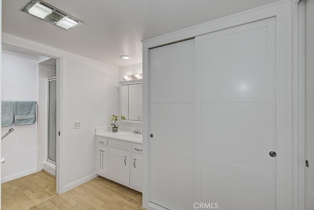 bathroom with vanity, an enclosed shower, and hardwood / wood-style flooring